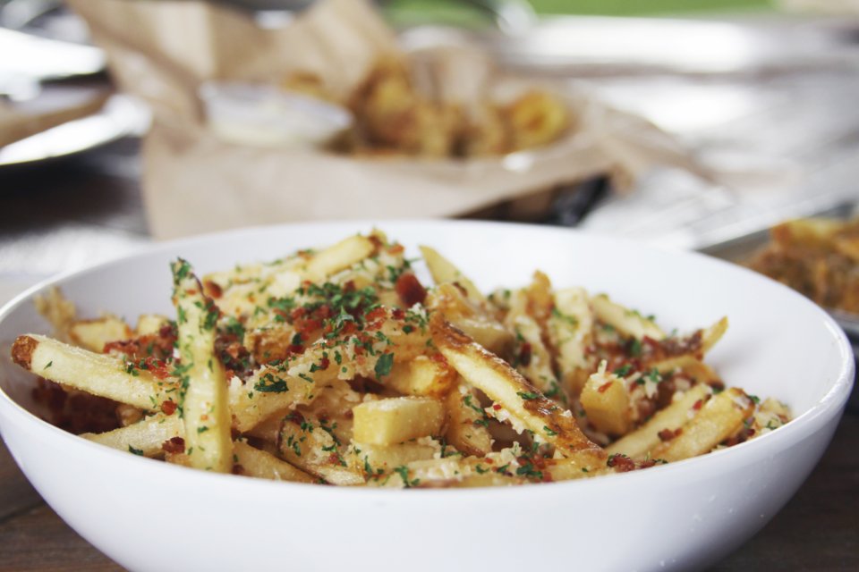 Air fryers make crispy seasoned potato fries in a white bowl