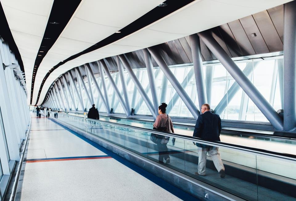 Carry on luggage rolling through a bright airport walkway