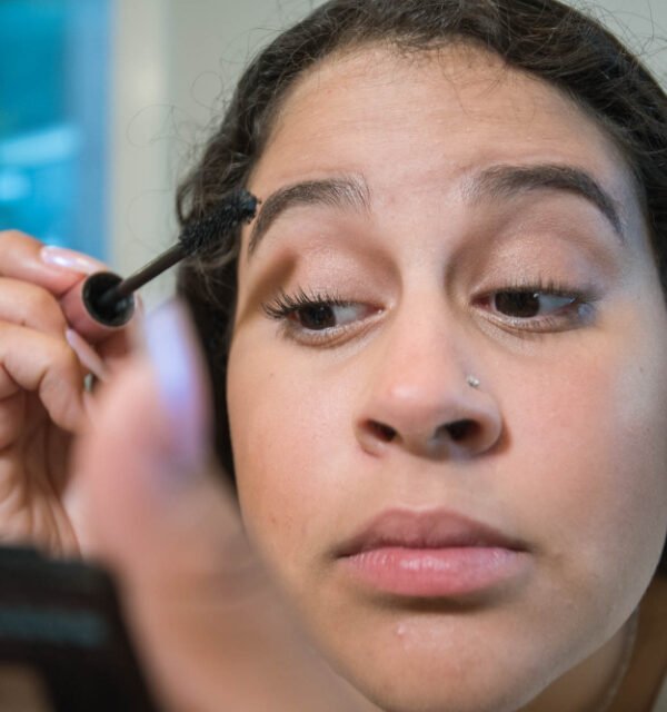 Woman applying mascara to her lashes