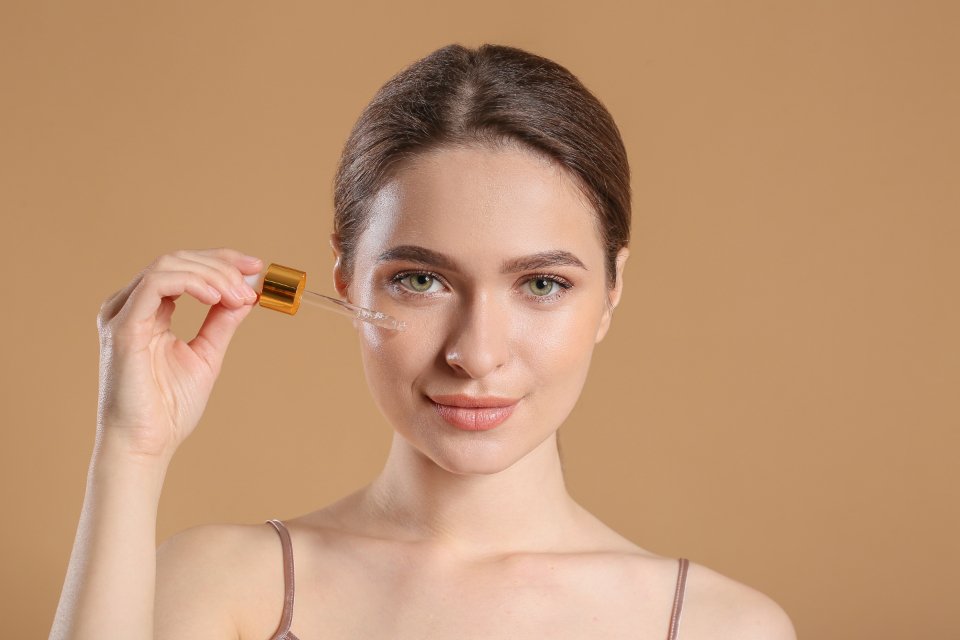 Woman applying one of the best vitamin c serums with a dropper