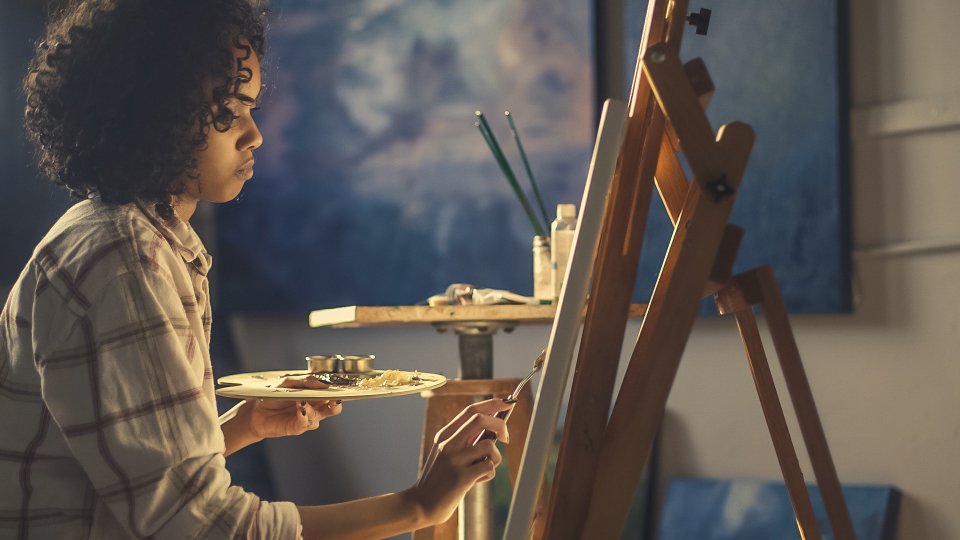 Artist painting a canvas on an easel, inspired by famous artist couples