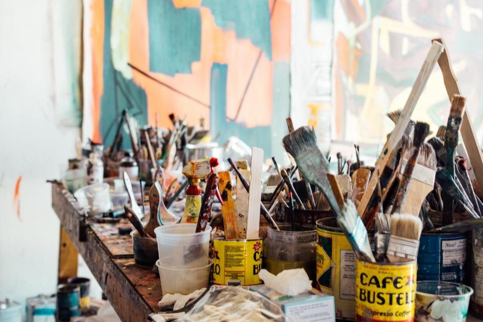 Cluttered studio table of paint brushes used by famous artist couples
