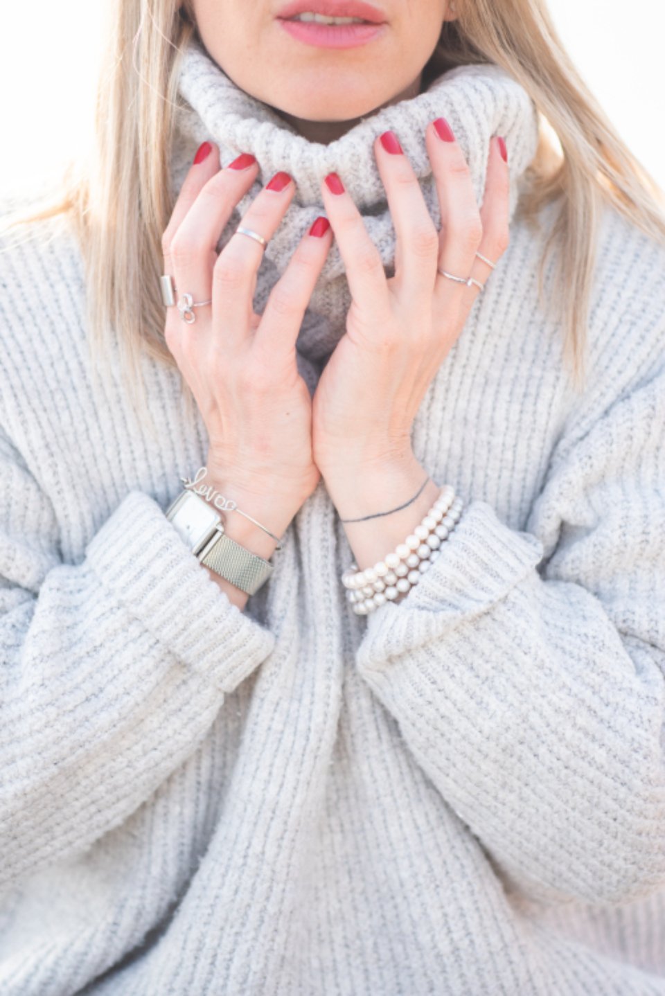 Bracelets on a wrist against a knit sweater, styling the best tennis bracelets