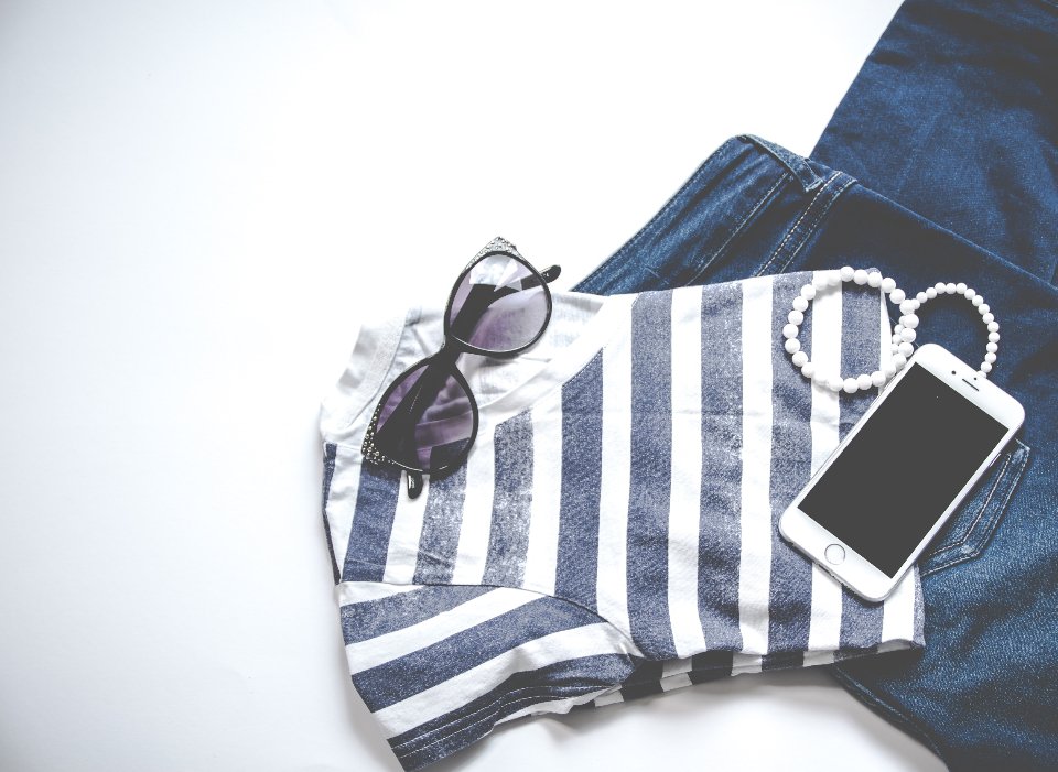 Breton stripes, jeans and sunglasses flat lay of Parisian style essentials