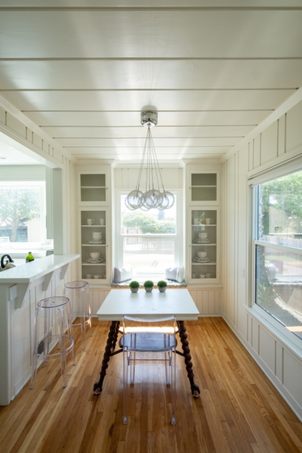 Bright white kitchen with a dining table and pendant light