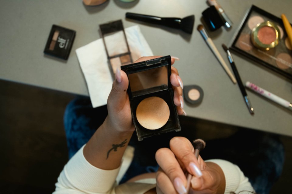 Woman holding one of the best bronzers in a compact