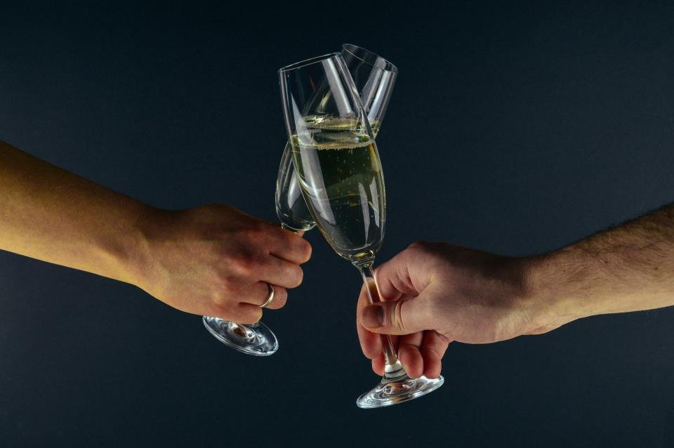 Champagne glasses raised in a toast at a holiday party