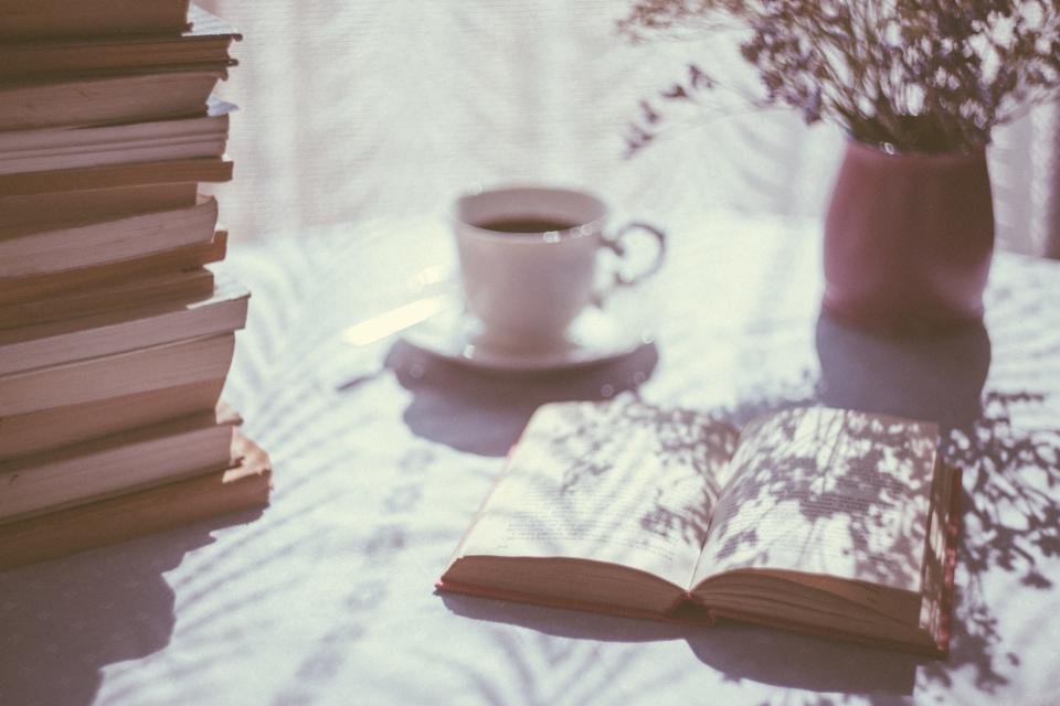 Best coffee table books stacked beside a cup of tea