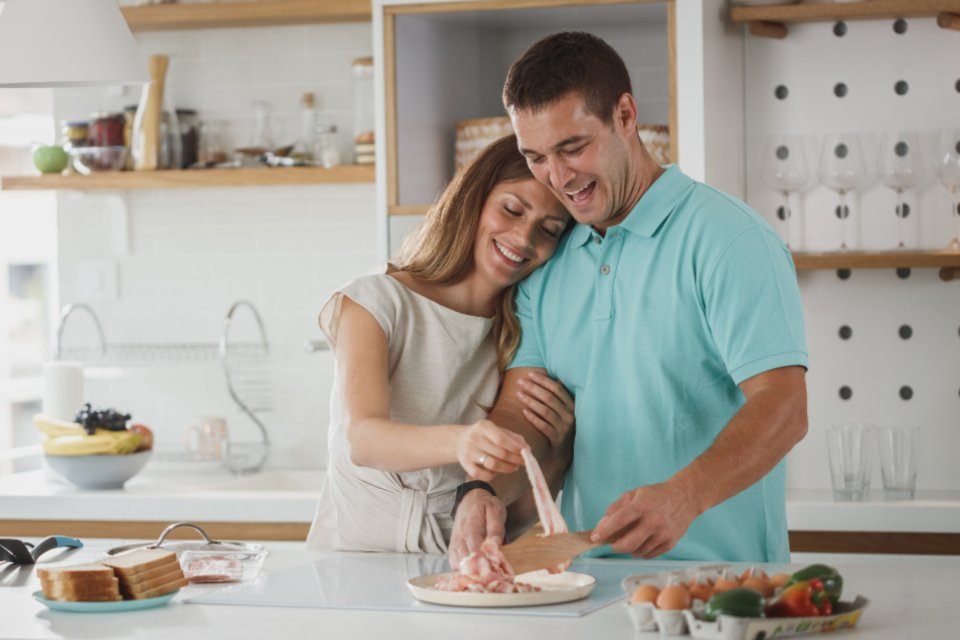 Couple cooking together in a bright home kitchen