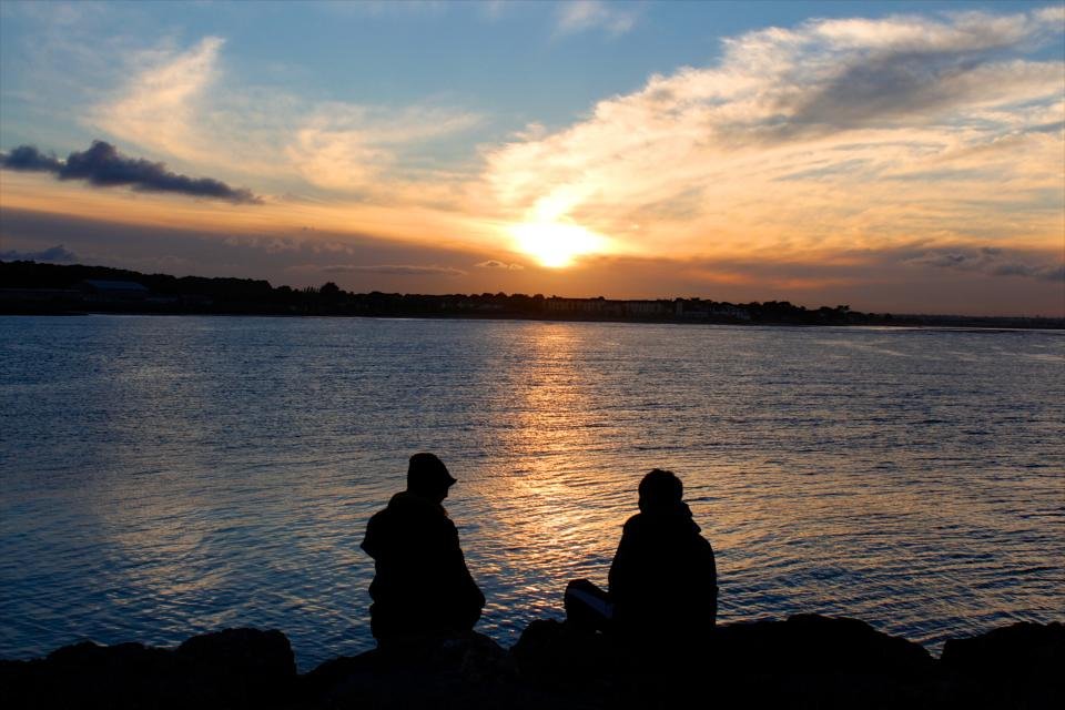 Couple watching the sunset by a lake, a symbol of Leo compatibility