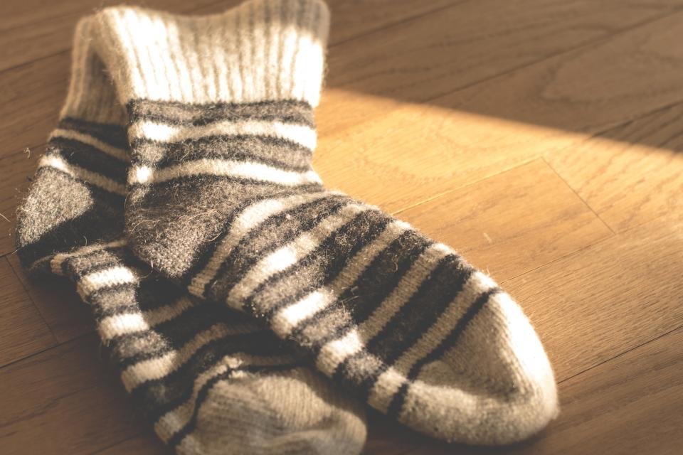 Warm knit wool socks on a wooden floor at home