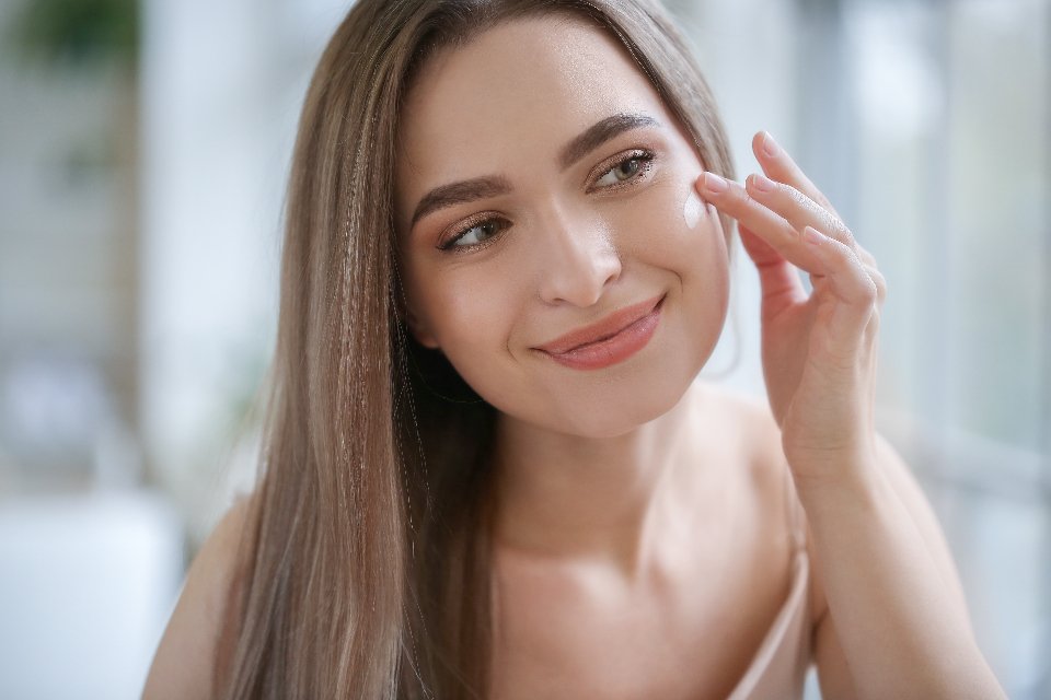 Woman applying a small amount of cream under her eye
