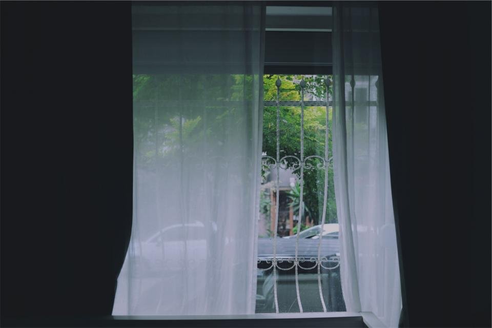 Blackout curtains framing a window in a dark room