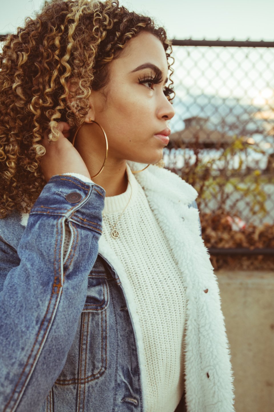 Denim jacket with a cozy sherpa collar over a knit sweater