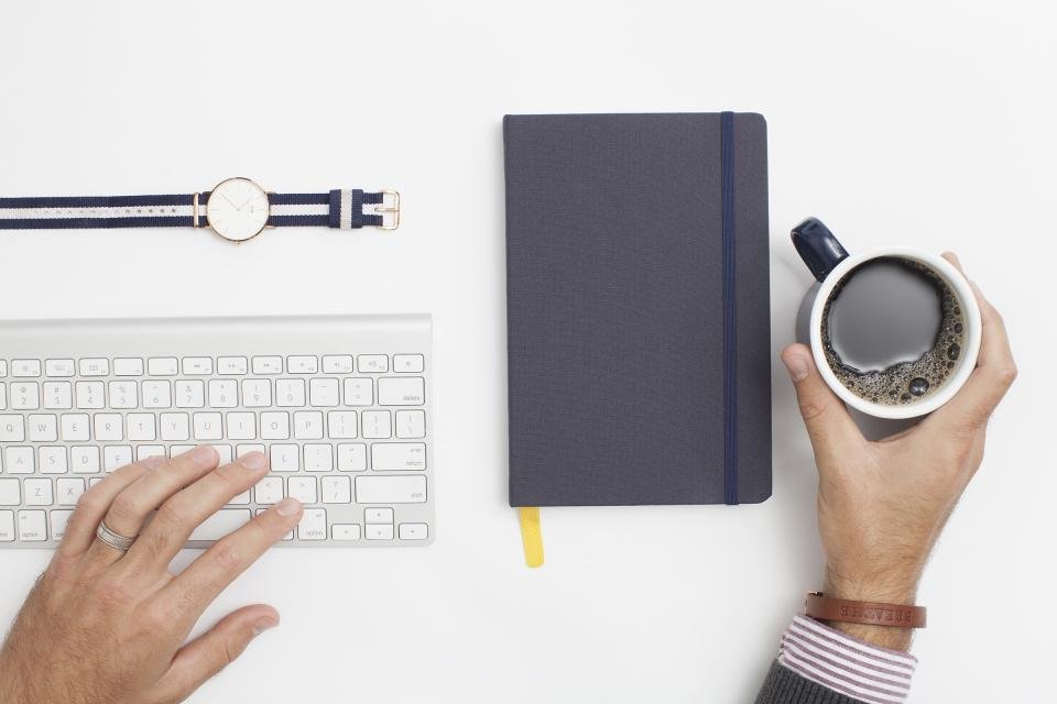 Desk with notebook and coffee, classic gifts for coworkers
