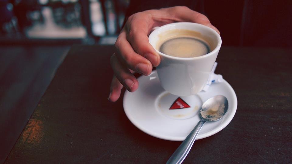 Fresh shot from a home espresso machine in a small cup
