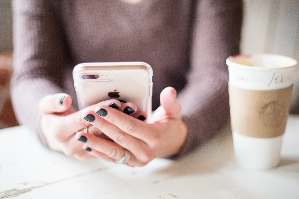 Woman checking a story on her smartphone to spot fake news