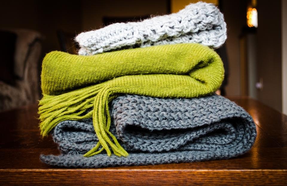 Stack of folded knit blankets, classic cozy gifts