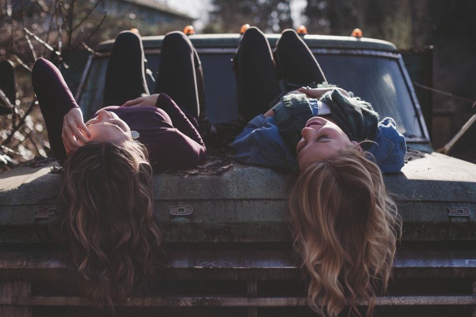 Two friends relaxing together on a truck, ideas for gifts for best friend adventures