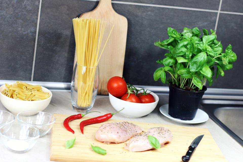 Gifts for home cooks inspired by fresh ingredients, basil and a chef knife on a kitchen counter