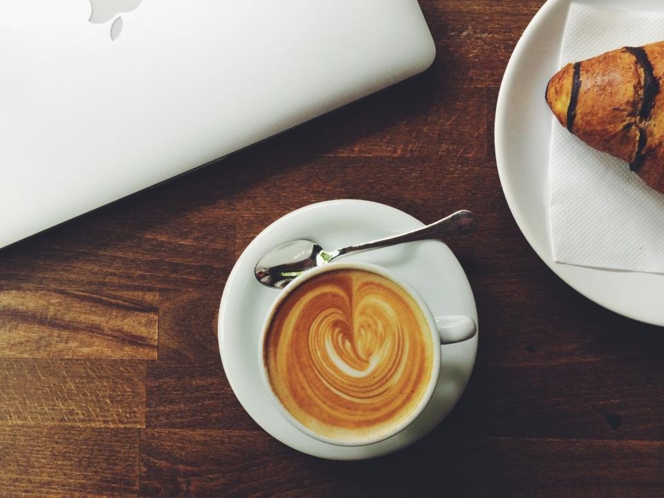 Latte with heart art in a cup on a wooden table