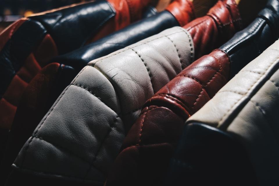 Leather and faux leather jackets hanging close together on a rack