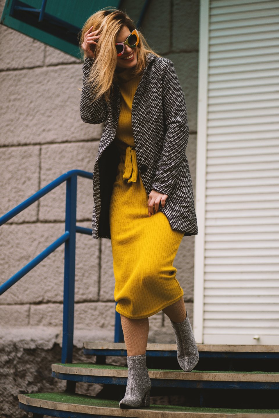 Woman in a long coat and boots on a city street