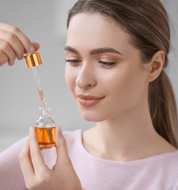 Woman holding a dropper bottle of face serum