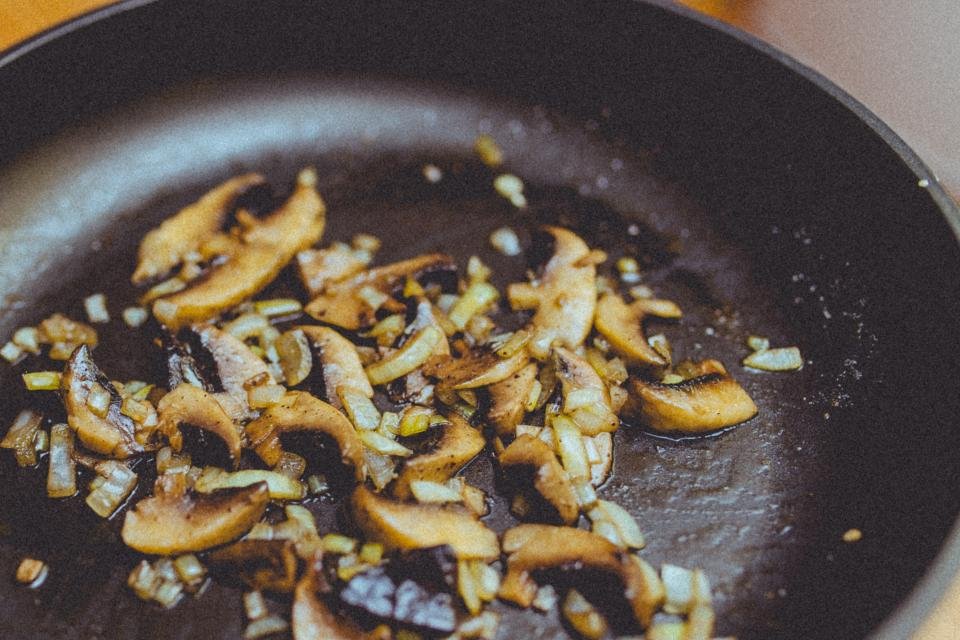 Mushrooms sizzling in a skillet from a cookware set