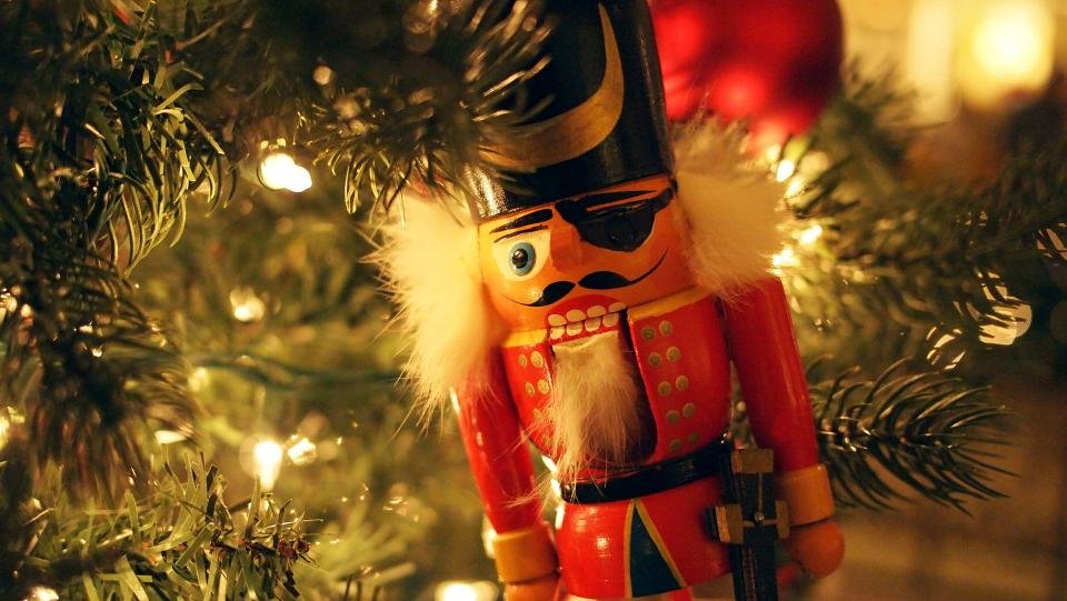 Nutcracker ornament hanging on a decorated Christmas tree