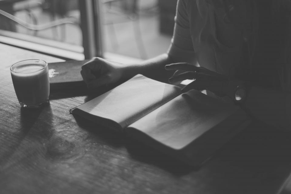 Open book and coffee on a cafe table