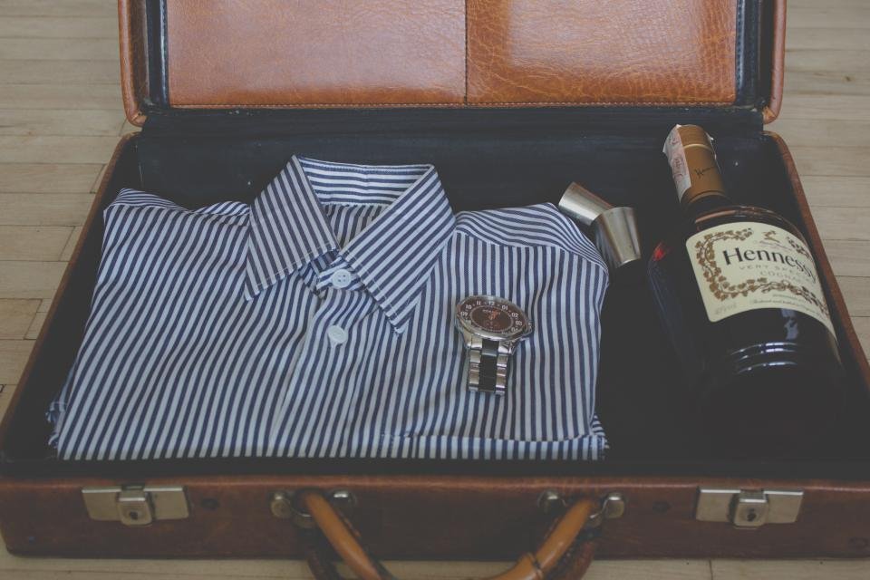 Open suitcase neatly packed with a folded striped shirt