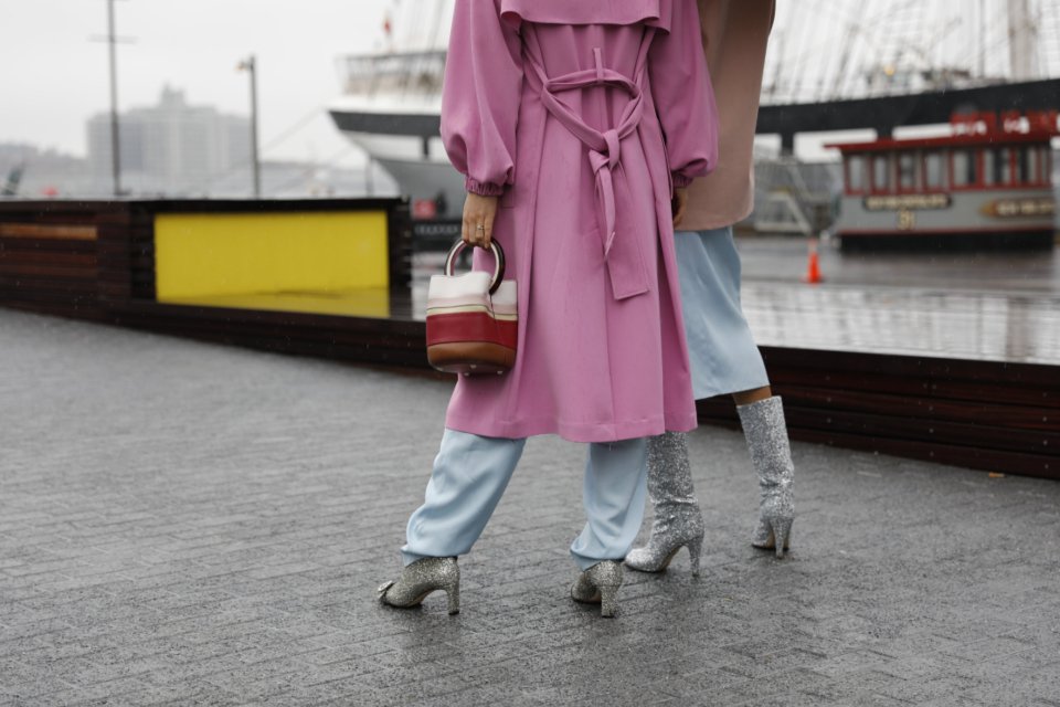 Woman wearing a long pink coat on a city waterfront