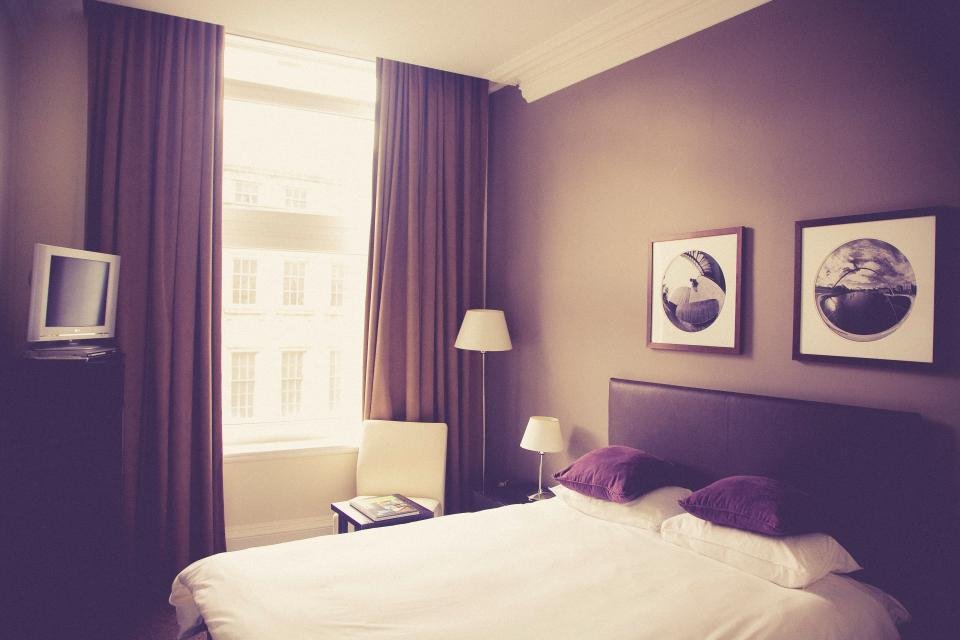 Elegant bedroom with crisp white bedding and purple accents