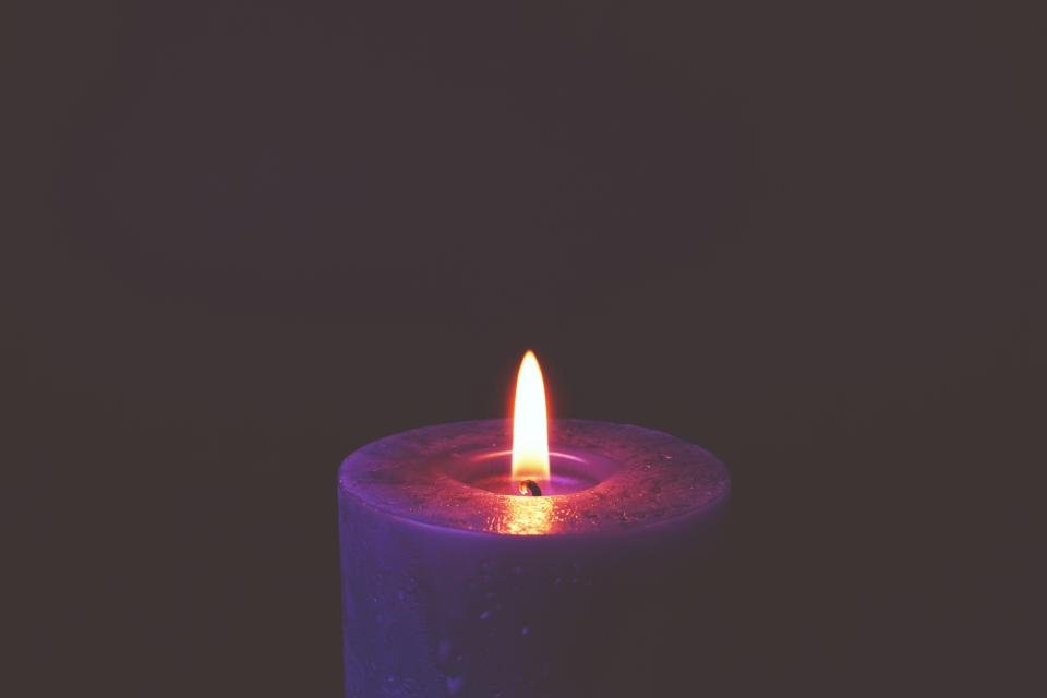 Lit luxury scented candles in a glass jar