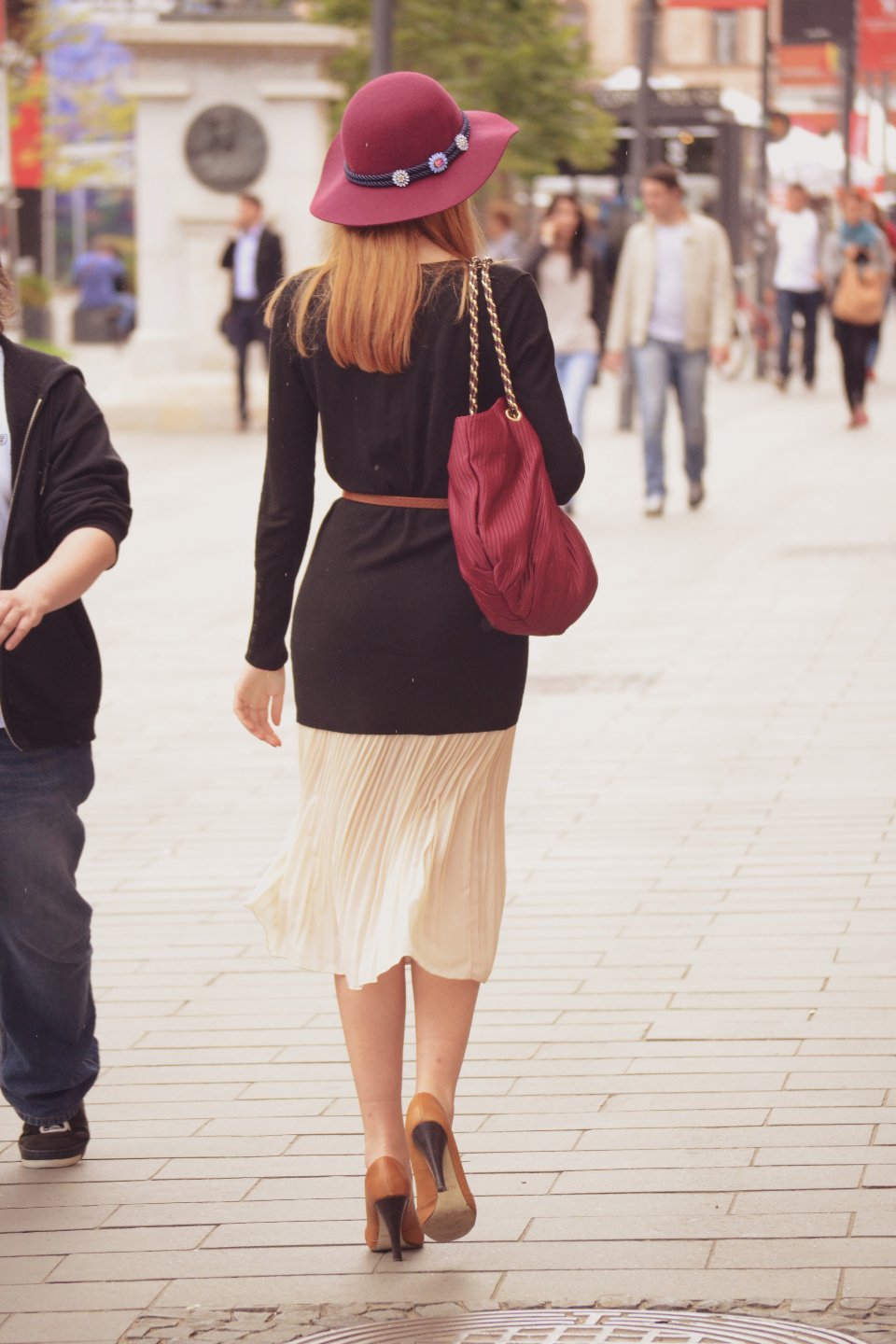 Woman carrying a red leather bag on a city street