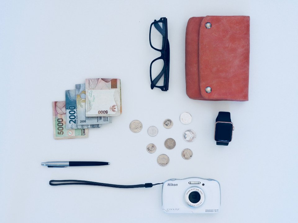 Wallets for women flat lay with red wallet, glasses and coins