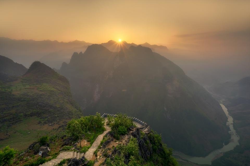 Rising sign meaning shown by the sun rising over a mountain valley