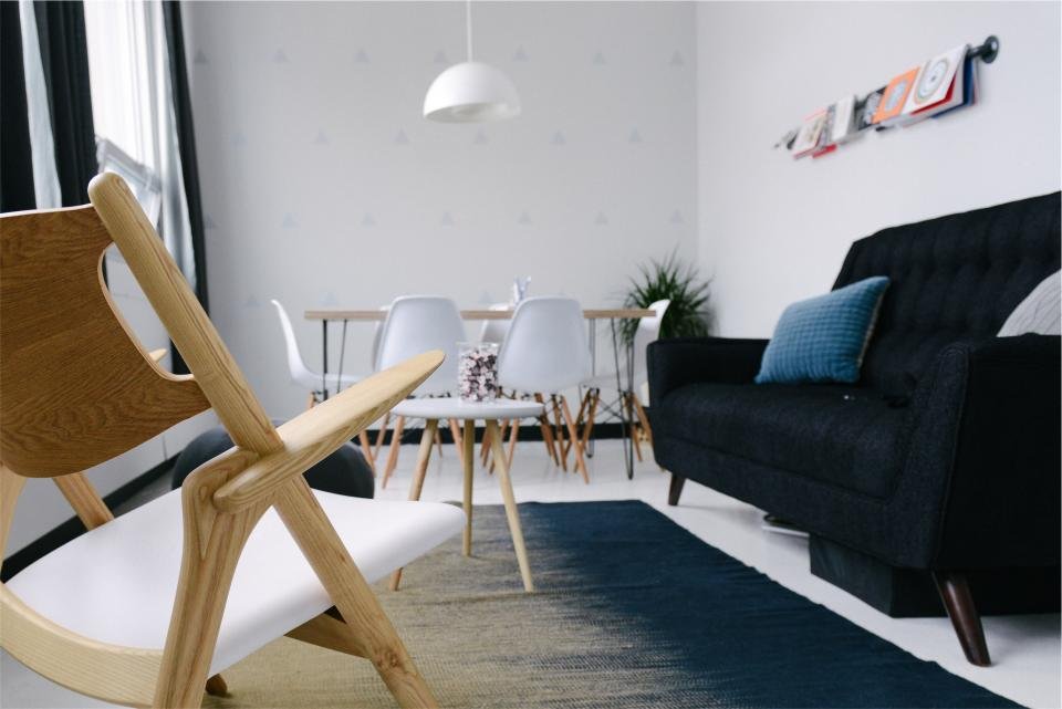Scandinavian living room with dark rug and wooden chair