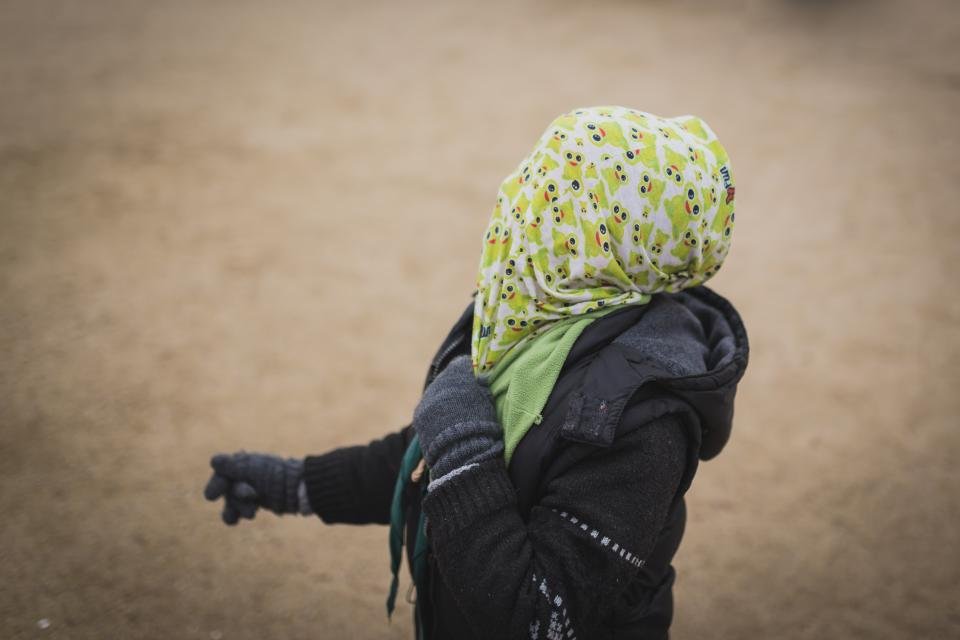 Person bundled in a hood, scarf and gloves on a cold day