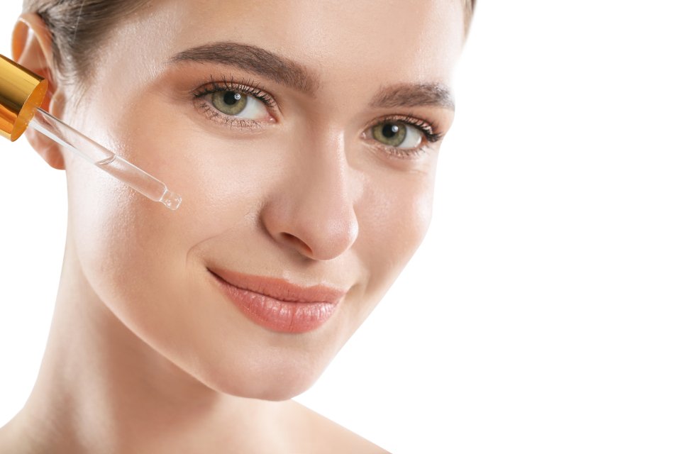 Woman applying one of the best luxury face serums for glowing skin
