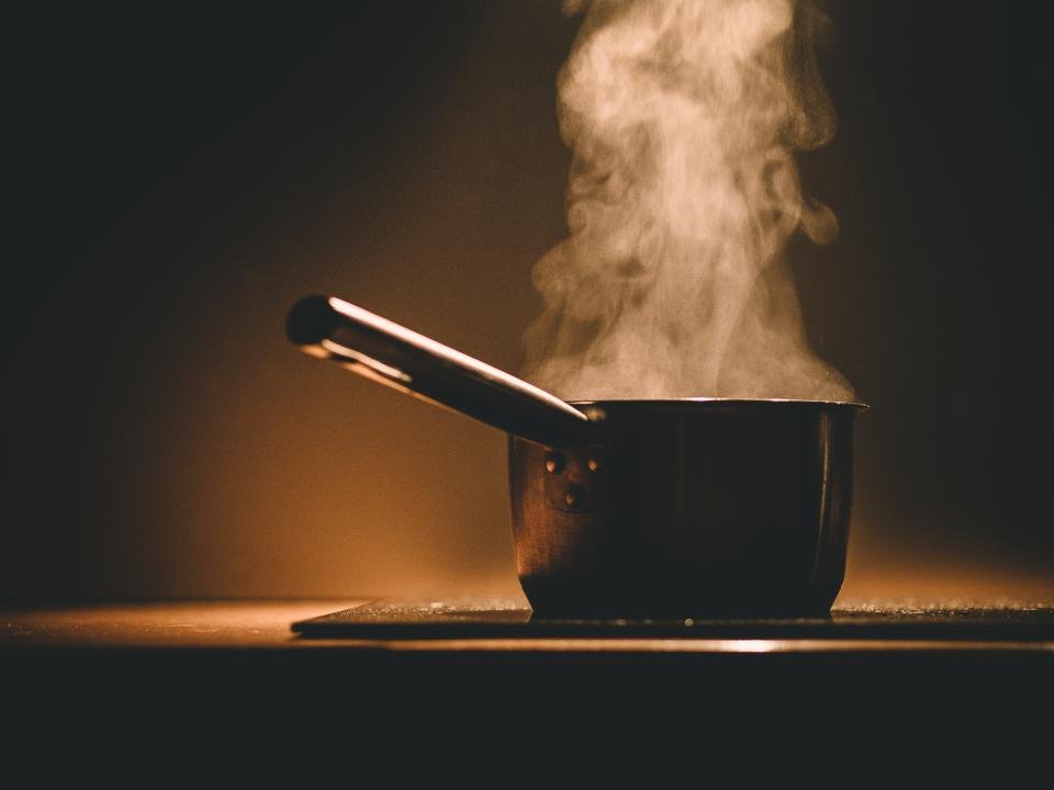 Dutch ovens simmering with steam rising on a stove
