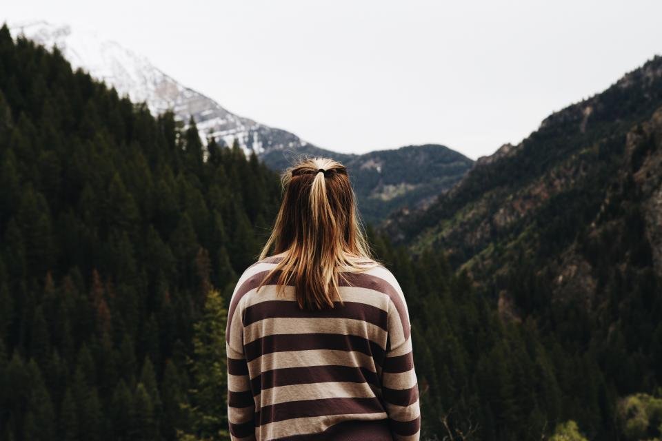 Woman in a striped knit sweater looking at the mountains