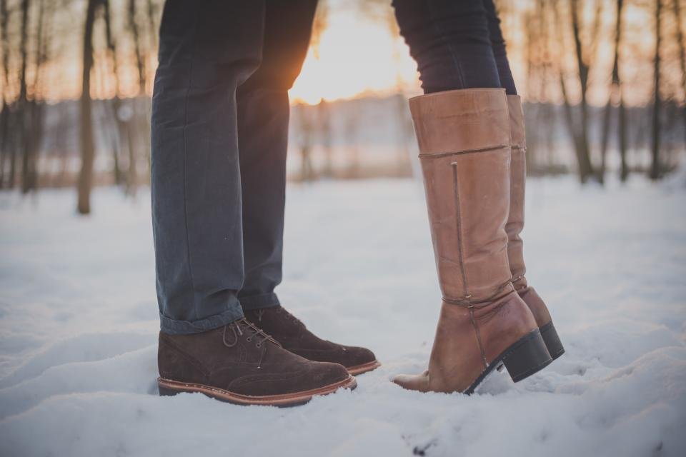 Tall leather winter boots standing in fresh snow