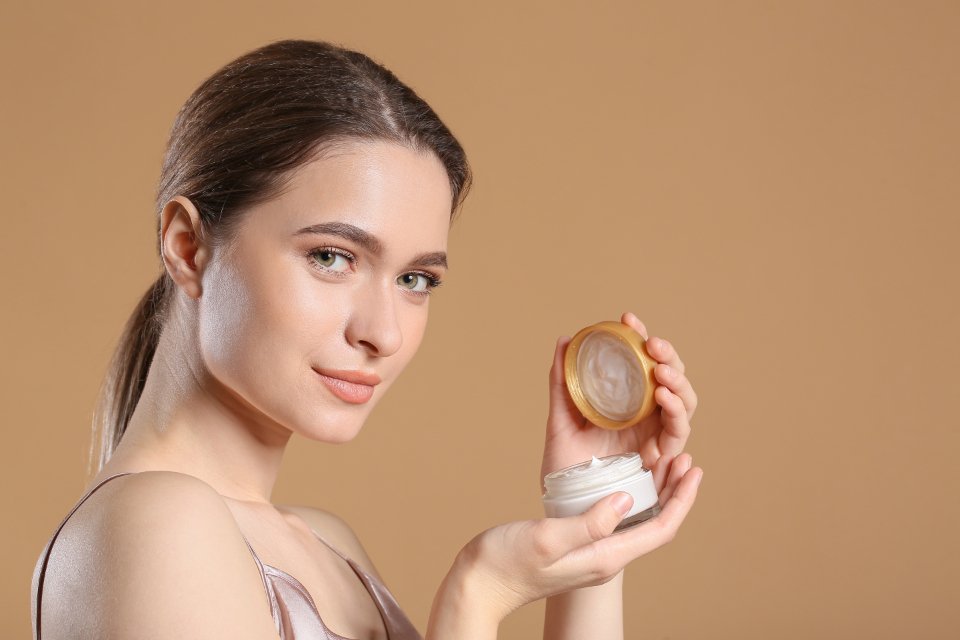 Woman holding a jar of one of the best tinted moisturizers