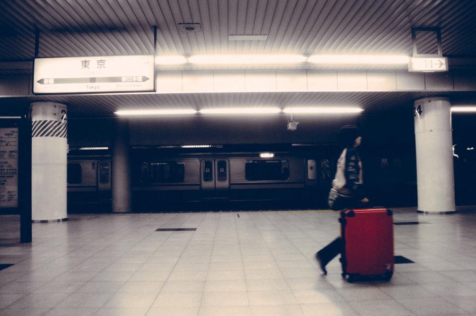 Woman with a travel duffle bag waiting at a station