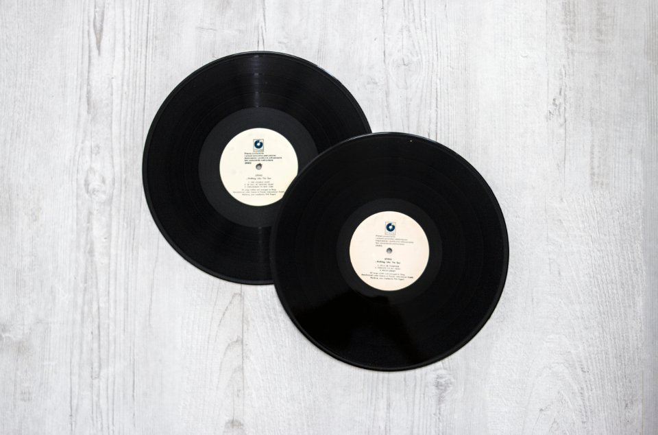 Two vinyl records on a wooden surface for beginners