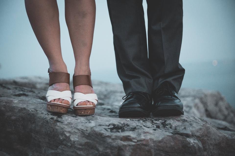 Women's flat sandals on a rock by the sea, a reminder to choose comfortable footwear