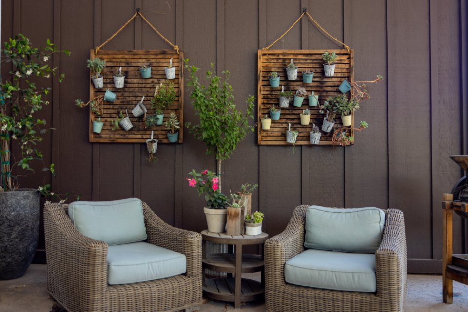 Two wicker patio armchairs with blue cushions on a porch