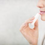 Woman applying lip balm